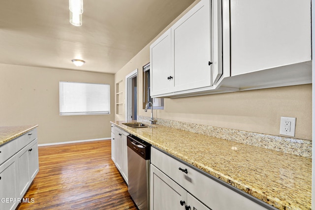 kitchen with stainless steel dishwasher, a sink, light stone countertops, and white cabinets