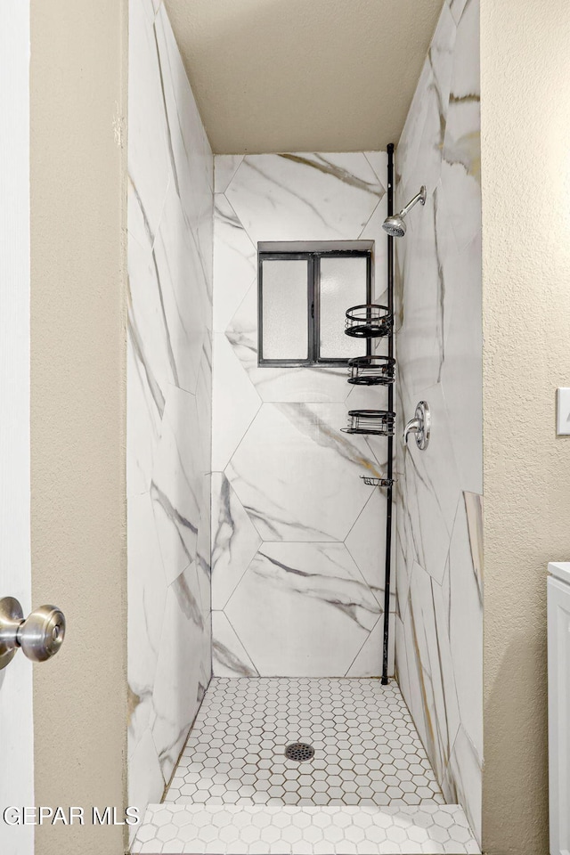 bathroom featuring a marble finish shower