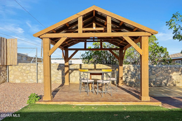 view of patio / terrace featuring a gazebo, outdoor dining space, and fence