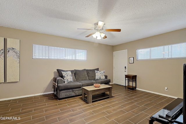 living area with a ceiling fan, wood finish floors, a textured ceiling, and baseboards