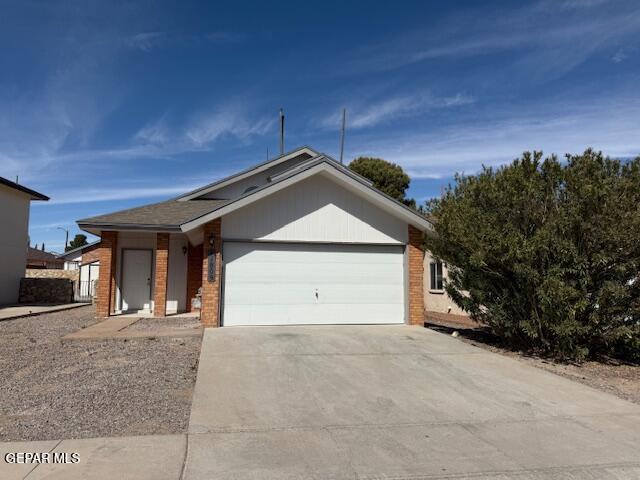 ranch-style home with an attached garage, concrete driveway, and brick siding