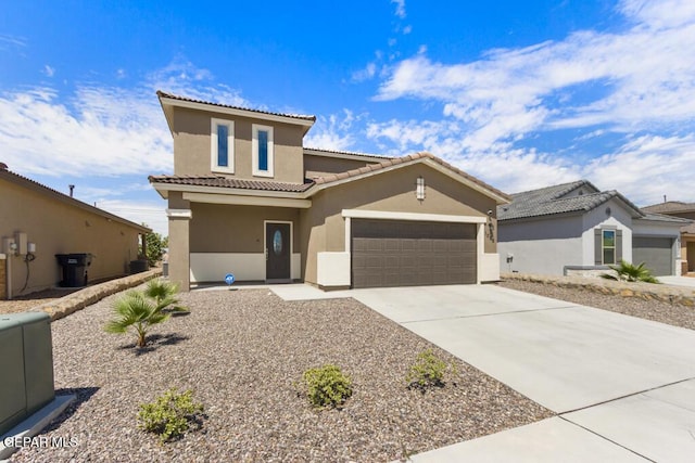 mediterranean / spanish house featuring driveway, an attached garage, a tiled roof, and stucco siding