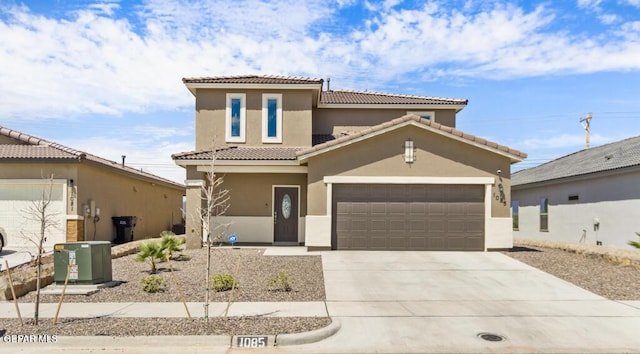 mediterranean / spanish-style house with concrete driveway, an attached garage, a tile roof, and stucco siding