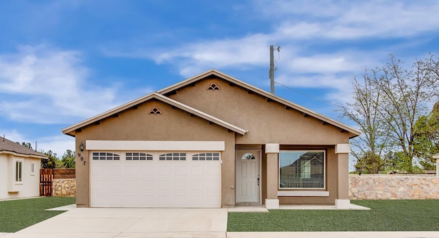 view of front of property with concrete driveway, fence, an attached garage, and stucco siding