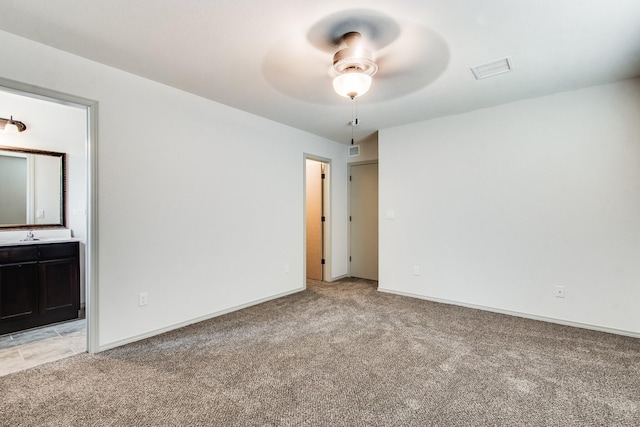 unfurnished bedroom featuring light colored carpet, connected bathroom, visible vents, and baseboards