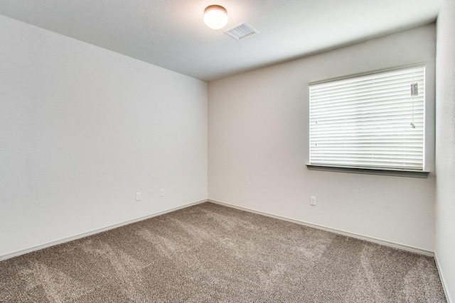 spare room with baseboards, visible vents, and carpet flooring