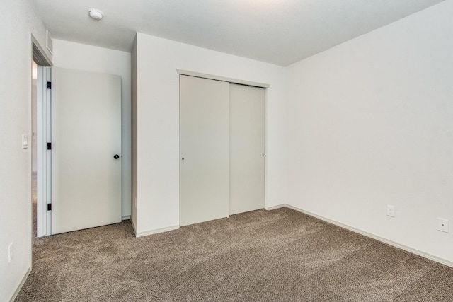 unfurnished bedroom featuring carpet floors and a closet