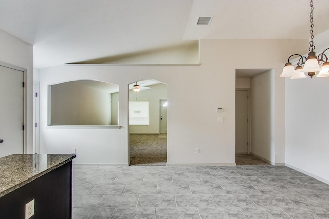 interior space featuring ceiling fan with notable chandelier, vaulted ceiling, visible vents, and baseboards