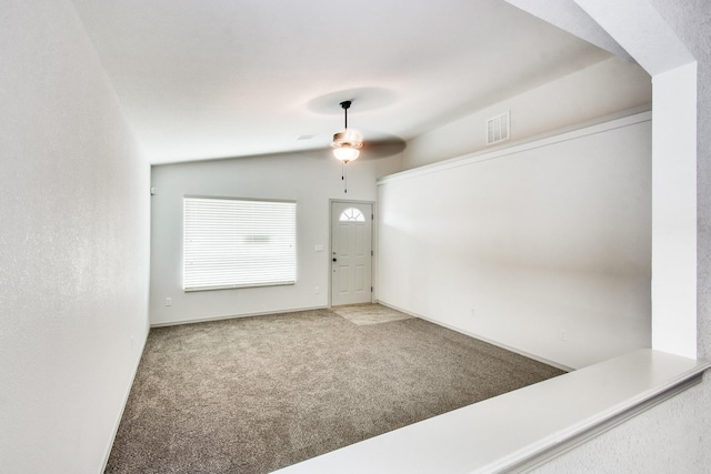 foyer entrance with carpet floors, lofted ceiling, visible vents, and a ceiling fan