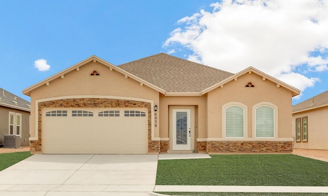 view of front of home with stucco siding, driveway, an attached garage, and central air condition unit