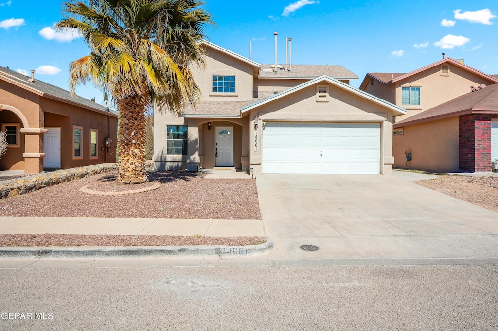 traditional-style home with concrete driveway, an attached garage, and stucco siding