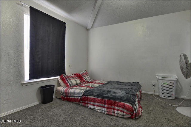 bedroom with baseboards, a textured wall, vaulted ceiling, a textured ceiling, and dark carpet