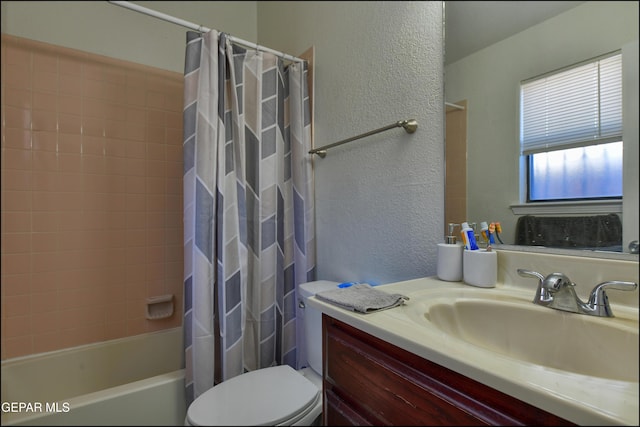 full bathroom featuring toilet, vanity, shower / bath combination with curtain, and a textured wall