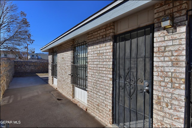 exterior space with brick siding, a patio area, and fence