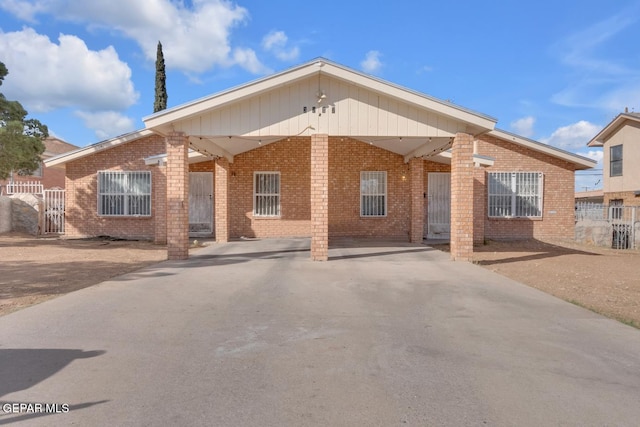 single story home with concrete driveway, brick siding, and fence