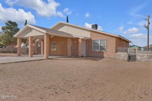 back of house featuring brick siding, fence, central AC, and a patio