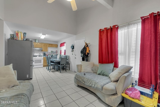 living area with vaulted ceiling with beams, light tile patterned flooring, and a ceiling fan