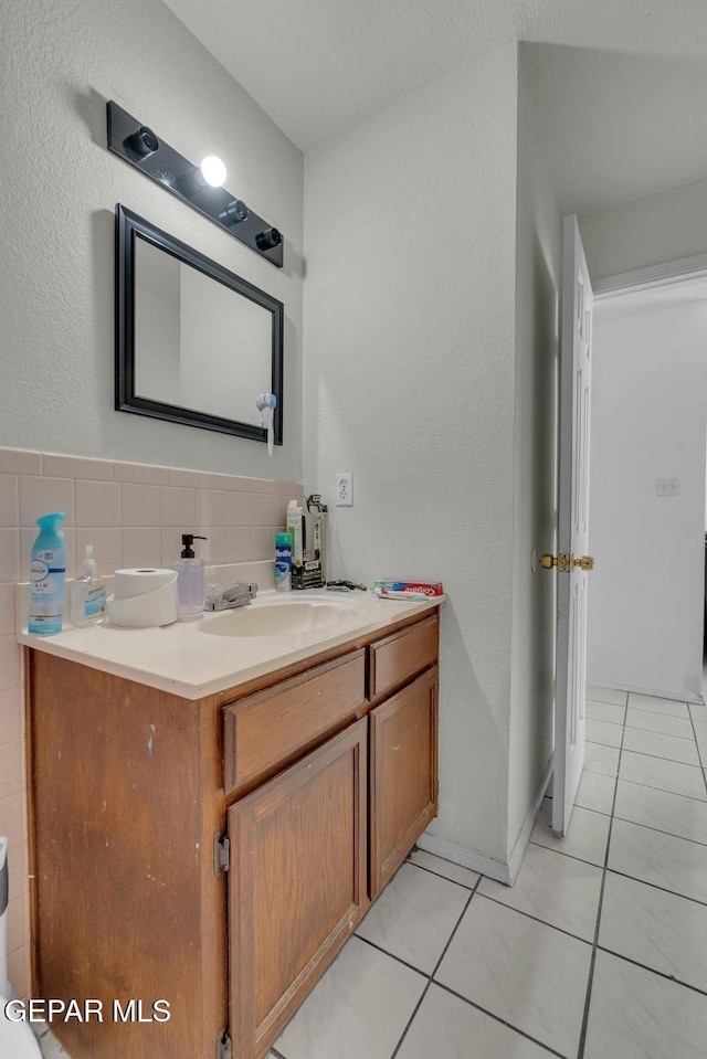 bathroom with tile patterned floors, tile walls, and vanity