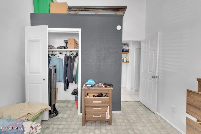 bedroom featuring light floors, a spacious closet, and a closet