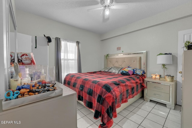 bedroom with light tile patterned flooring, ceiling fan, and a textured ceiling