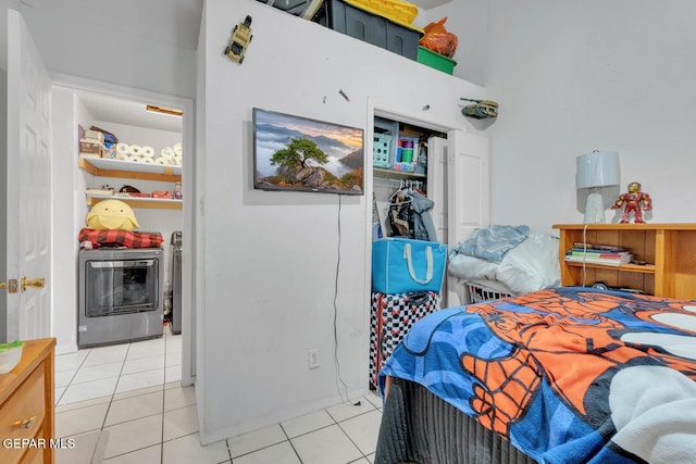 bedroom featuring light tile patterned floors and washing machine and dryer