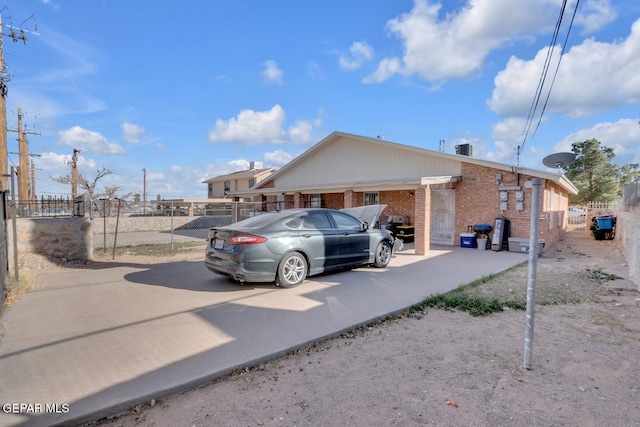 view of property exterior featuring brick siding and fence