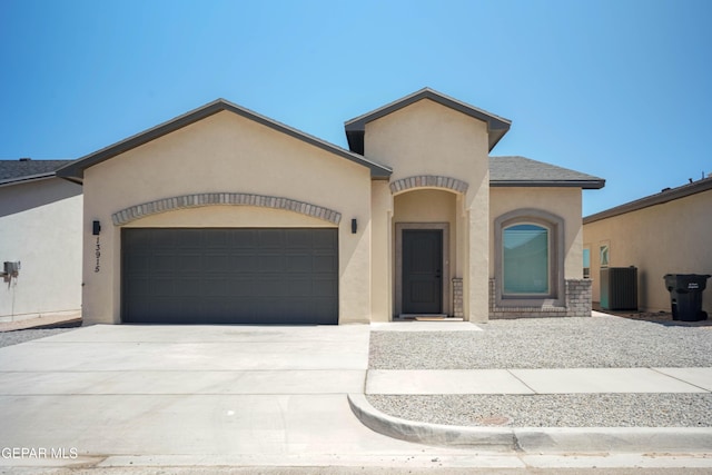 view of front of property with a garage, driveway, central AC unit, roof with shingles, and stucco siding