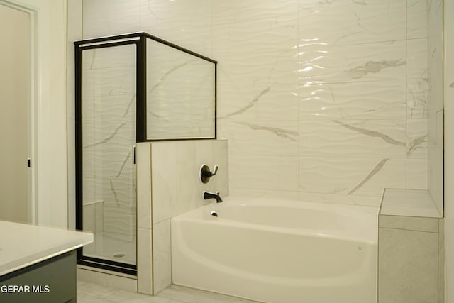 bathroom with a stall shower, a garden tub, and vanity