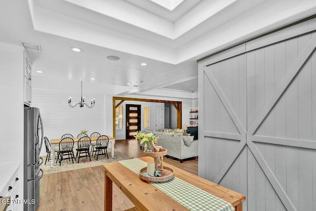 living area with a skylight, visible vents, wood finished floors, a chandelier, and recessed lighting