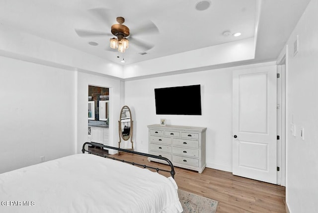 bedroom with ceiling fan, recessed lighting, visible vents, light wood finished floors, and a raised ceiling