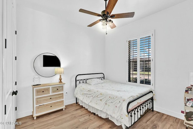 bedroom with wood finished floors, a ceiling fan, and baseboards