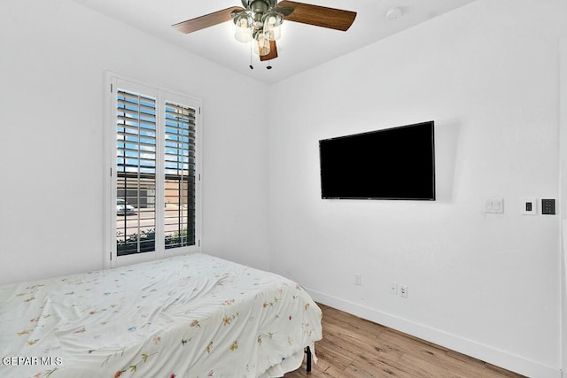 bedroom featuring ceiling fan, baseboards, and wood finished floors