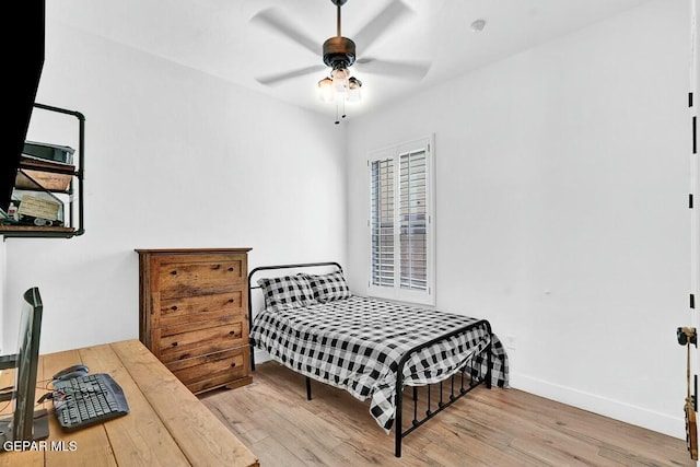 bedroom with a ceiling fan, baseboards, and wood finished floors