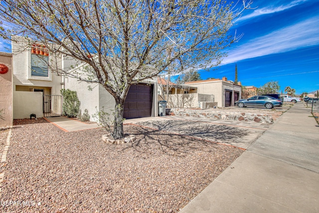 view of front of house featuring driveway, an attached garage, and stucco siding