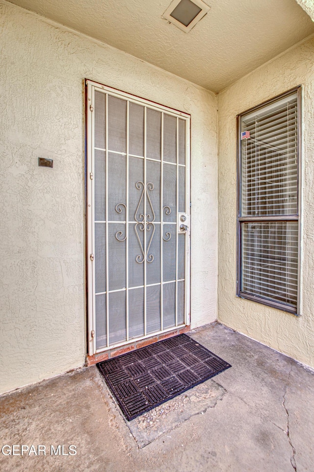 view of exterior entry featuring stucco siding