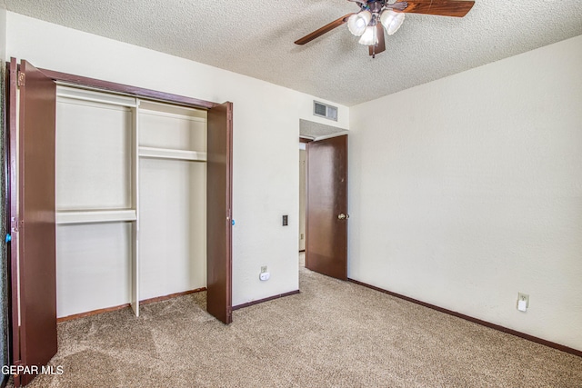 unfurnished bedroom with a closet, visible vents, carpet flooring, a textured ceiling, and baseboards