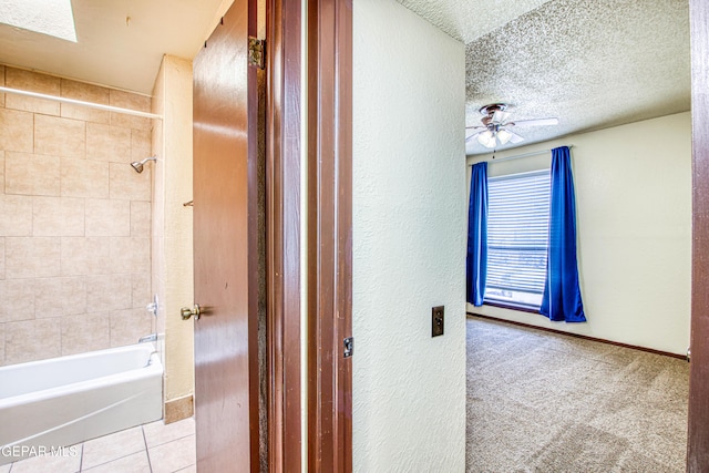 corridor with baseboards, light colored carpet, a textured ceiling, and light tile patterned flooring