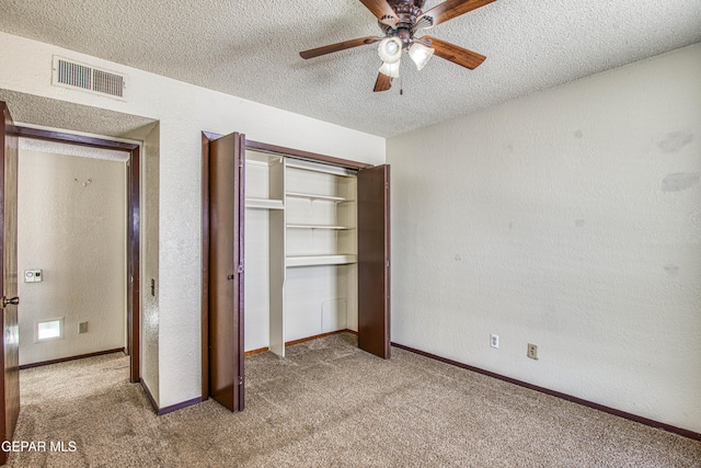 unfurnished bedroom featuring light carpet, a textured ceiling, visible vents, and a closet