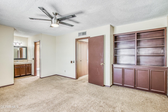 unfurnished bedroom with light carpet, ensuite bath, baseboards, and visible vents