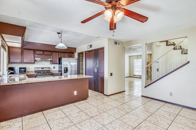 kitchen featuring visible vents, appliances with stainless steel finishes, a peninsula, under cabinet range hood, and pendant lighting