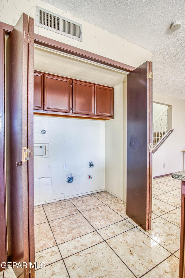 laundry room featuring cabinet space, visible vents, hookup for an electric dryer, washer hookup, and light tile patterned flooring