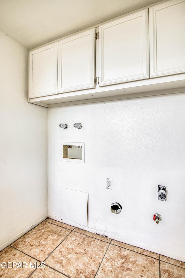 clothes washing area featuring light tile patterned floors, cabinet space, and hookup for a gas dryer