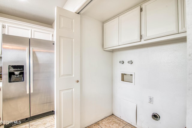 washroom featuring washer hookup, cabinet space, light tile patterned flooring, and hookup for a gas dryer