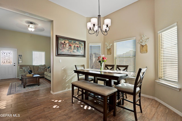 dining space featuring baseboards, dark wood finished floors, and a notable chandelier