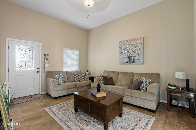 living area with ceiling fan, baseboards, and wood finished floors