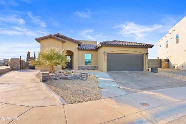 mediterranean / spanish-style home featuring driveway, an attached garage, a tiled roof, and stucco siding