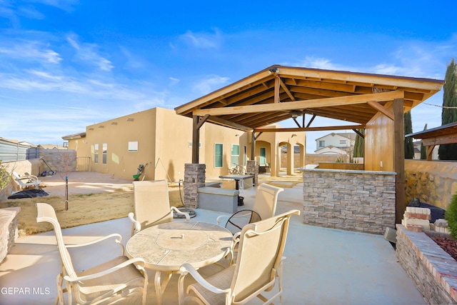 view of patio with an outdoor bar and fence