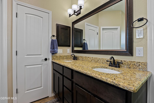 bathroom featuring a textured wall, double vanity, and a sink