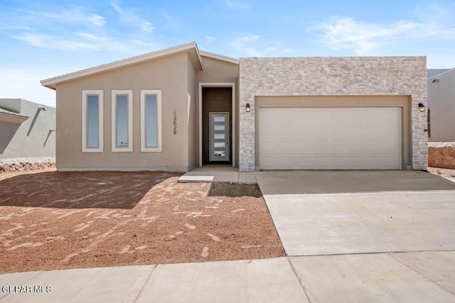 view of front of house with driveway, an attached garage, and stucco siding