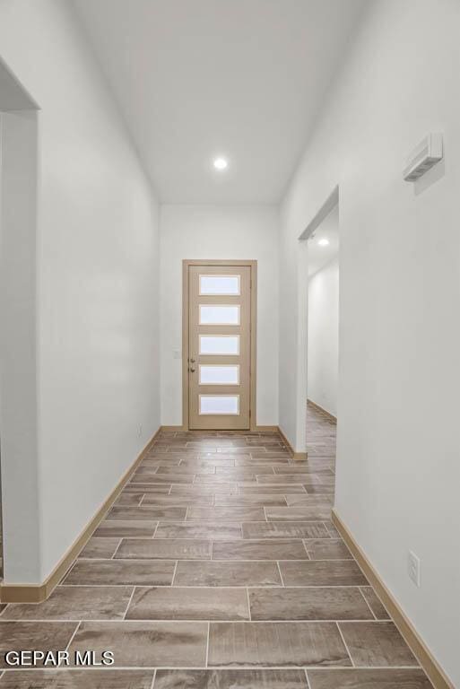 hallway featuring wood tiled floor and baseboards